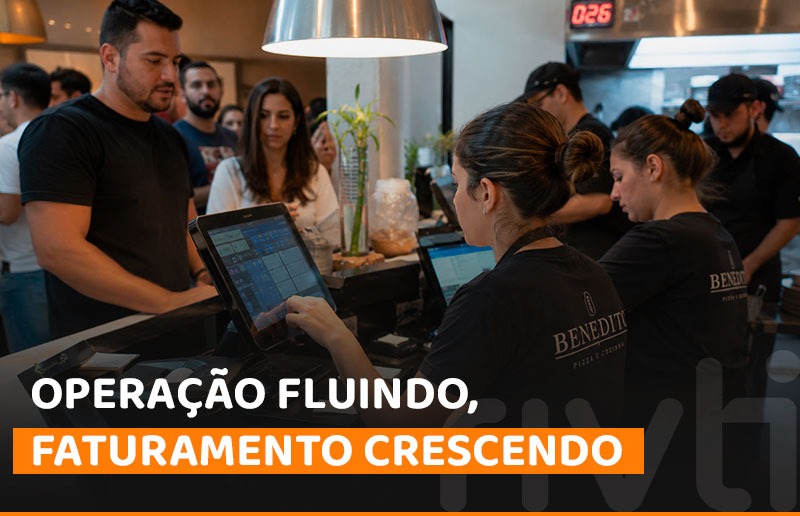 Equipe de restaurante operando sistema de frente de caixa em horário de pico.